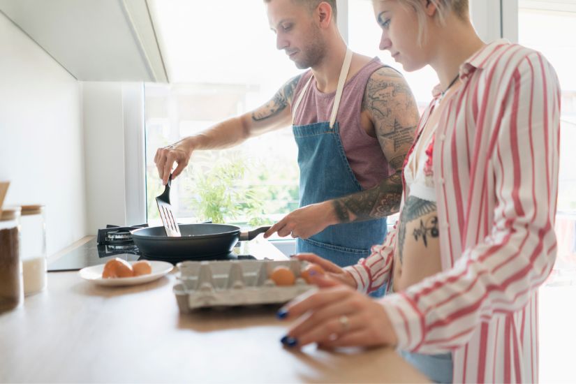 With a little planning and creativity, you can eat healthy on a budget. Two person cooking in their kitchen.