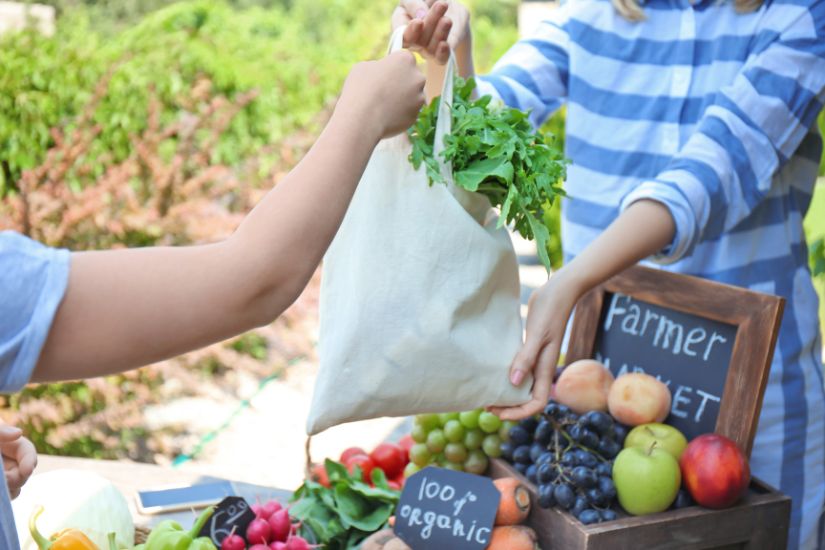 By focusing on seasonal foods, you can also add variety to your diet while saving money. Somebody buying fresh food on a farmers market.