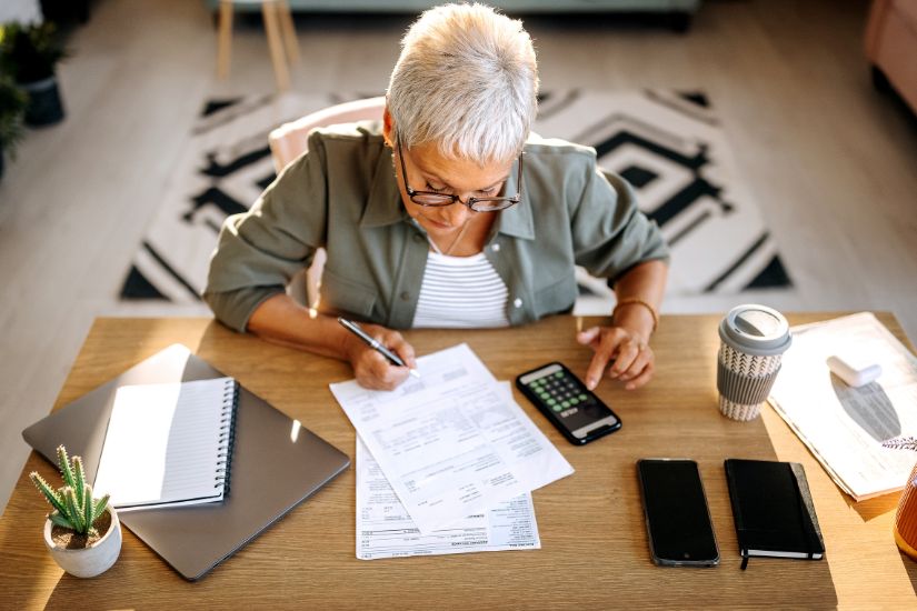 It is crucial to have a clear overview of your financial situation to get out of debt. A woman analyzing her finances.
