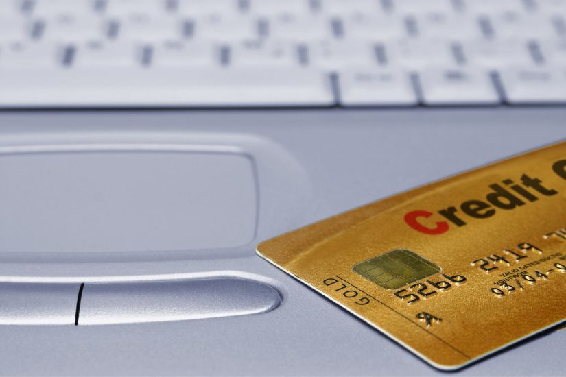 Choose just one card that aligns with your spending habits. A laptop with one golden credit card.