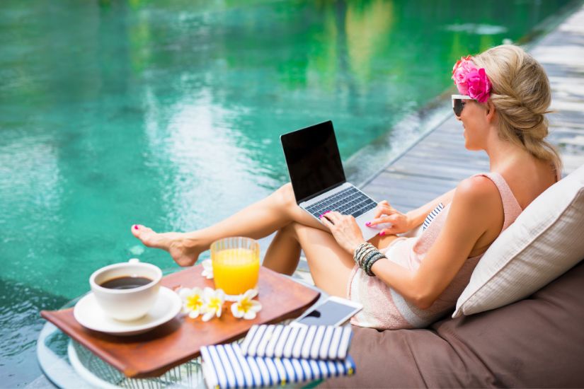 Imagine this: picture yourself living your best financial life. A woman sitting on a pool, having coffee and orange juice while working on her laptop, financially free.