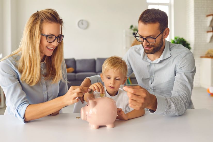 Financial literacy. A couple with its child and a piggy bank, talking about money to the child.
