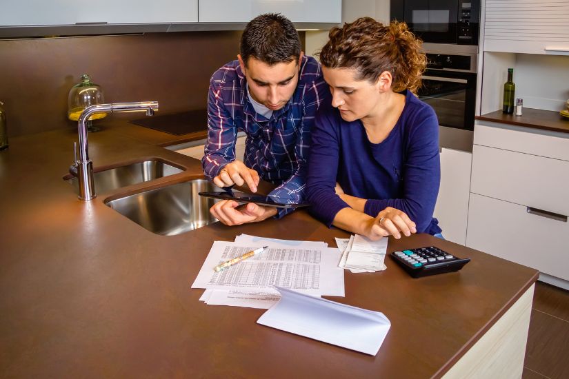 Joint Accounts and Individual Accounts to manage money as a couple. A couple is in the kitchen and has a look at the bank statements.