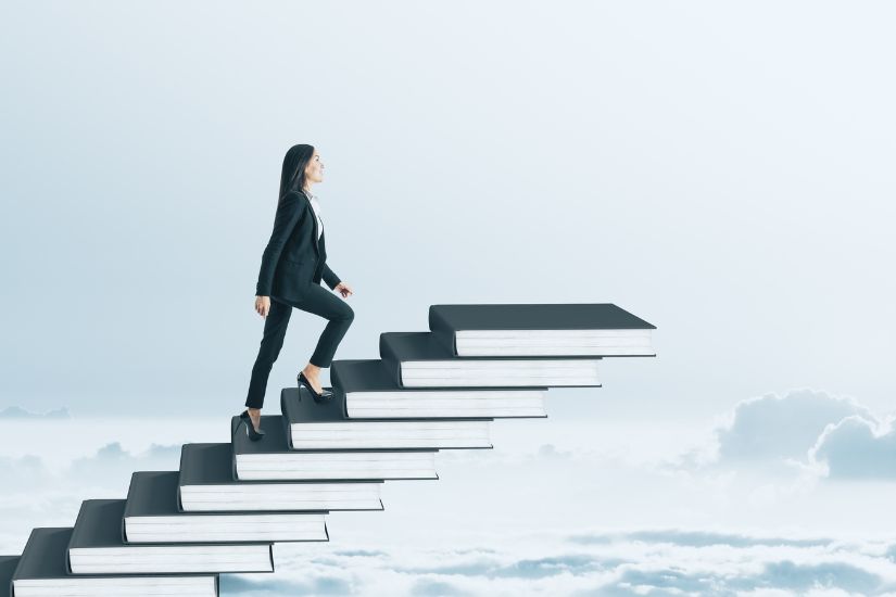 Grab your favorite coffee, sit down on your couch, and read about the latest money tips. A woman climbing a ladder of books.