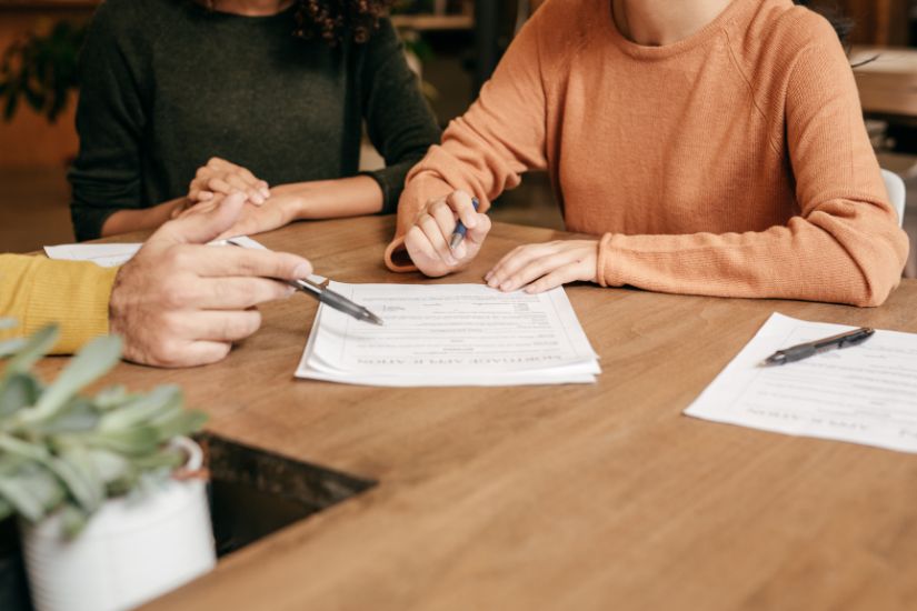 Long-term financial goals are those you plan to achieve in five years or more. A couple planning their goals on a table.