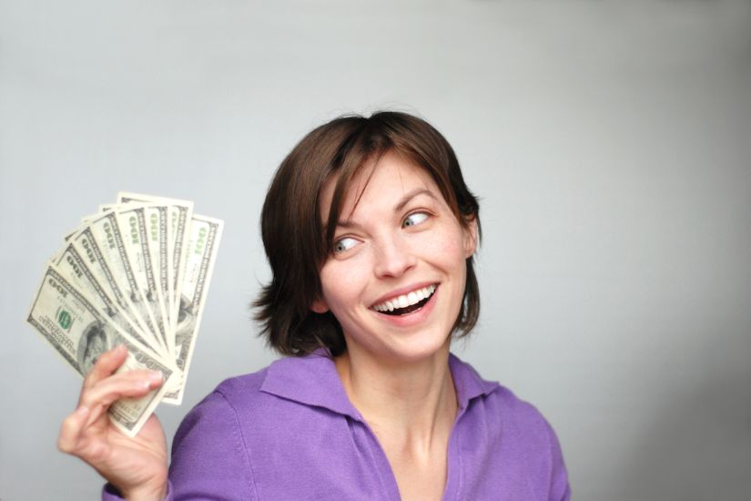 Increase Your Income. Look for opportunities to boost your income. A smiling woman with more money in her hand.