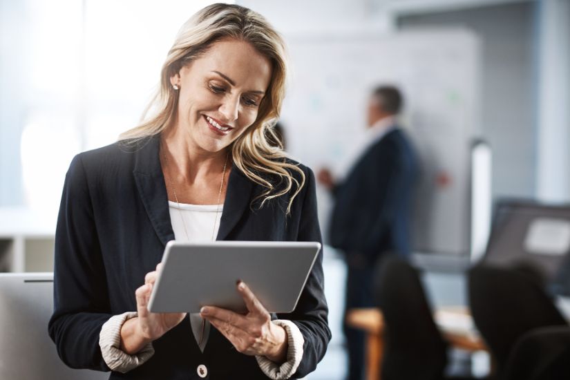 A strong online presence is critical to attracting and engaging your target audience. A woman holding a tablet in her hand.