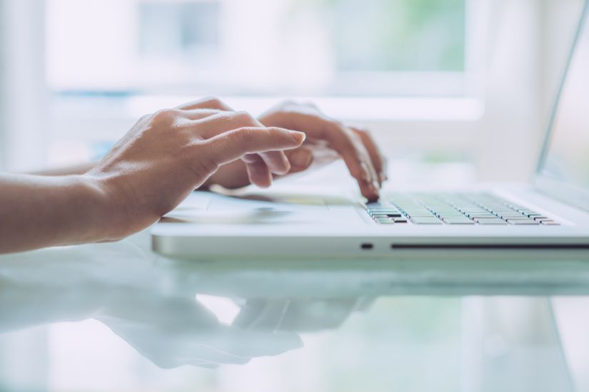 Get paid to write about topics you love by becoming a freelance writer. image of someone writing on a laptop