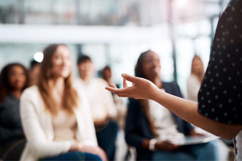 Focus on strategies that drive traffic and encourage engagement to build and maintain a dedicated readership. A woman speaking in front of her audience