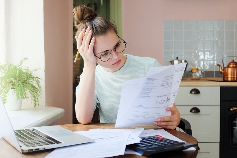 Debt management is another critical aspect of your fall financial check-up. A woman looking at her debt statement