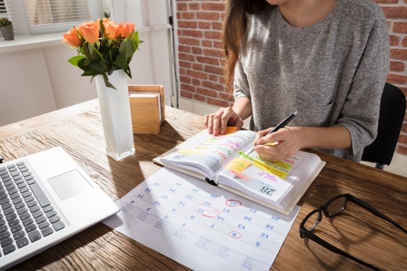 You need to be careful not only with your time but also with your energy. Picture of a busy but organized desk setup with a planner