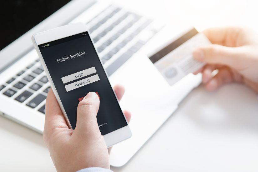 Your checking account is the foundation of your Minimalist Banking System. A simple image of a bank card and coffee on a clean desk with a laptop showing a checking account balance.